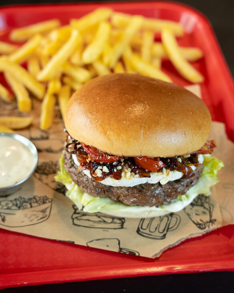Burger maison avec frites croustillantes et sauce on the side.